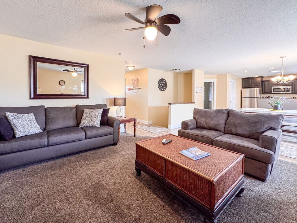 Bright, inviting living room with plush seating, neutral tones, and open flow into the kitchen and dining area