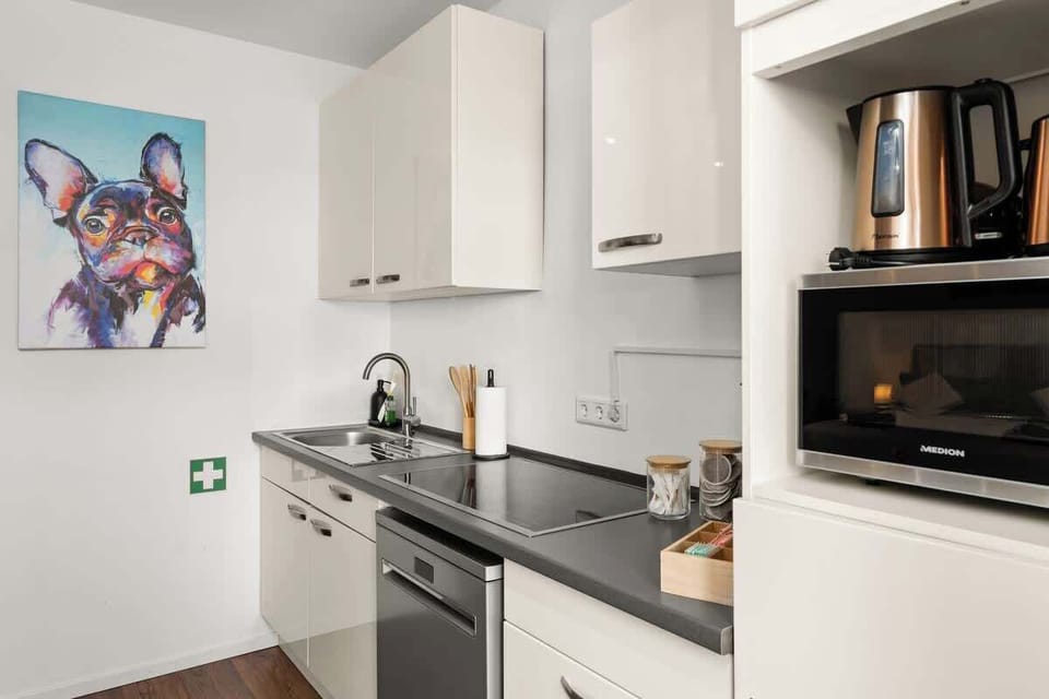 Die Küche ist mit einer Spülmaschine, einem Herd, einer Mikrowelle mit Back-und Grillfunktion, Toaster, Wasserkocher, Eierkocher und einer Senseo Kaffeemaschine ausgestattet sowie Besteck, Geschirr, Wasser-, Sekt- und Weingläser, Töpfe und Pfannen.