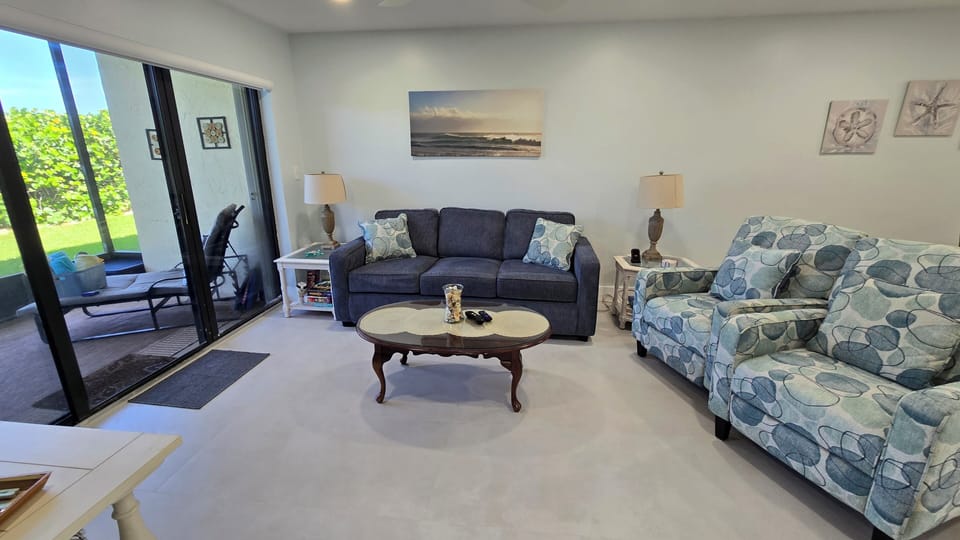 Sofa bed and a pair of recliners with a wireless phone charger on the end table