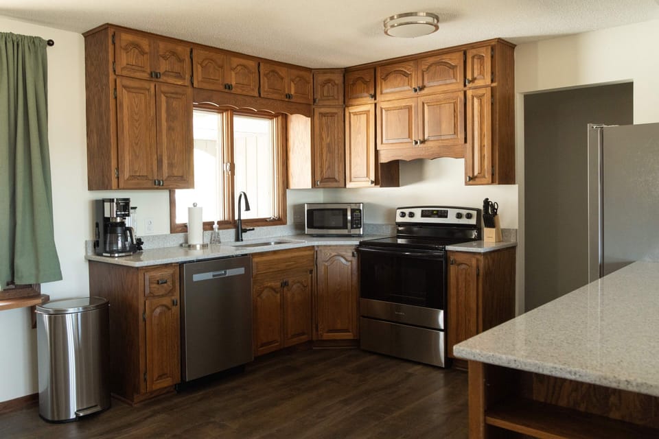 Full kitchen with dishes, utensils, pots, and pans