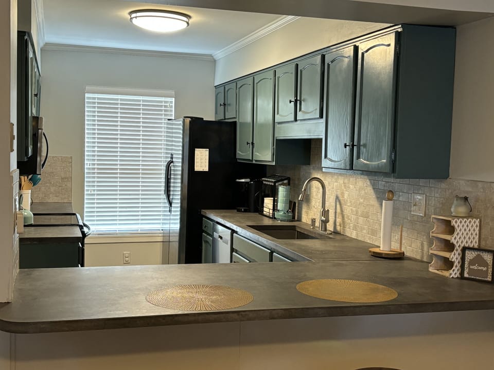 Stocked kitchen: coffee pot, Keurig, waffle iron, pots, pans & baking needs.