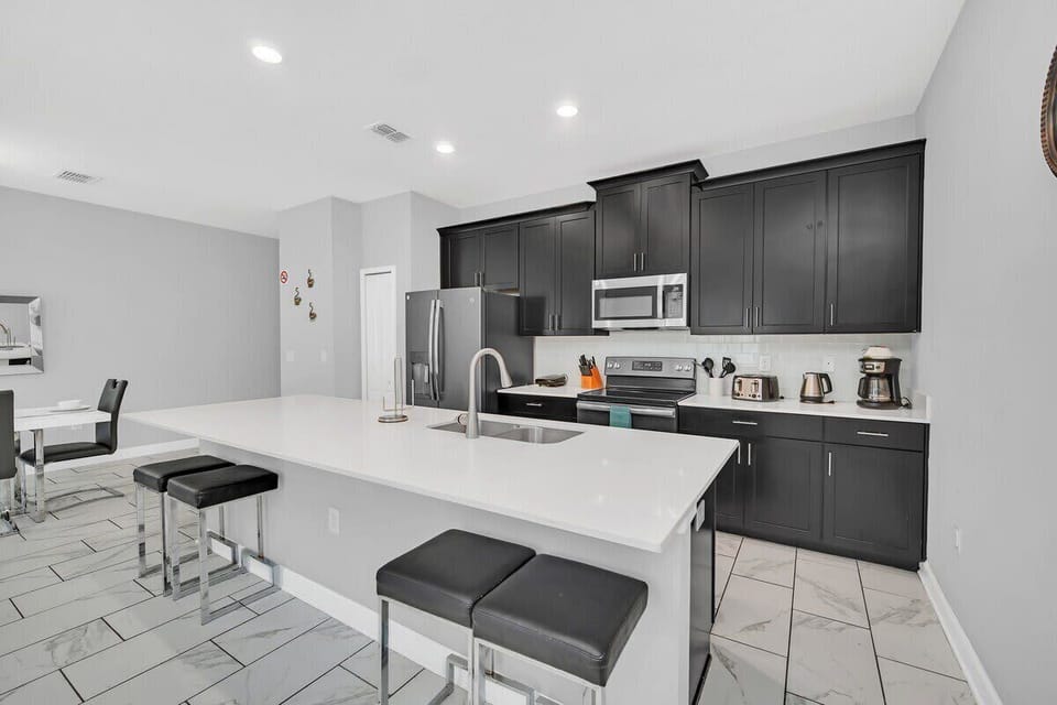 Cook with ease in the fully equipped open-concept kitchen featuring modern stainless steel appliances, generous counter space, and a layout perfect for gathering with family and friends.