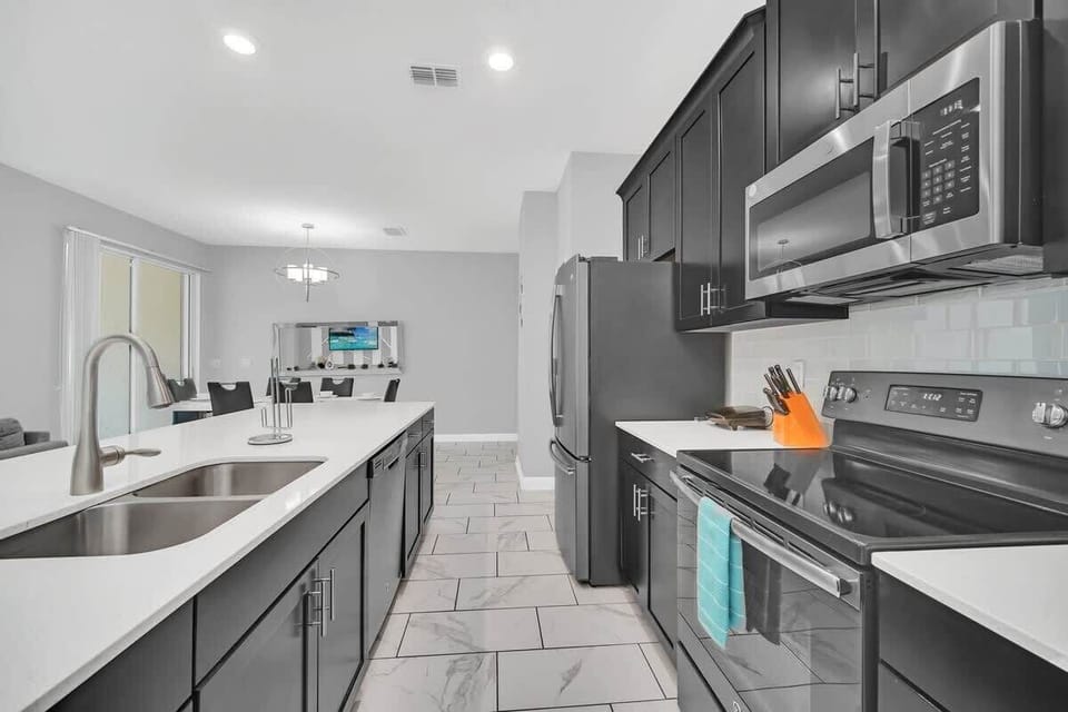 Cook with ease in the fully equipped open-concept kitchen featuring modern stainless steel appliances, generous counter space, and a layout perfect for gathering with family and friends.