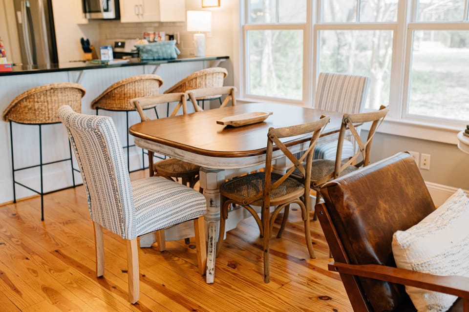 The farmhouse table in the dining area is perfect for gathering around for meals or games.