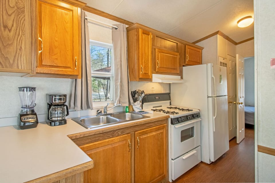 The partial kitchen includes a stove top, oven, refrigerator, coffee maker, blender, and more!