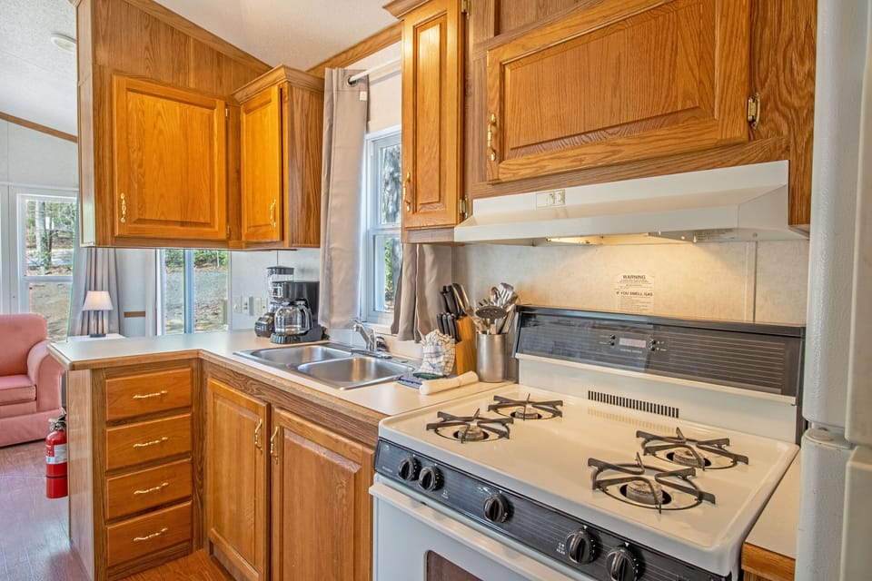 The partial kitchen includes a stove top, oven, refrigerator, coffee maker, blender, and more!