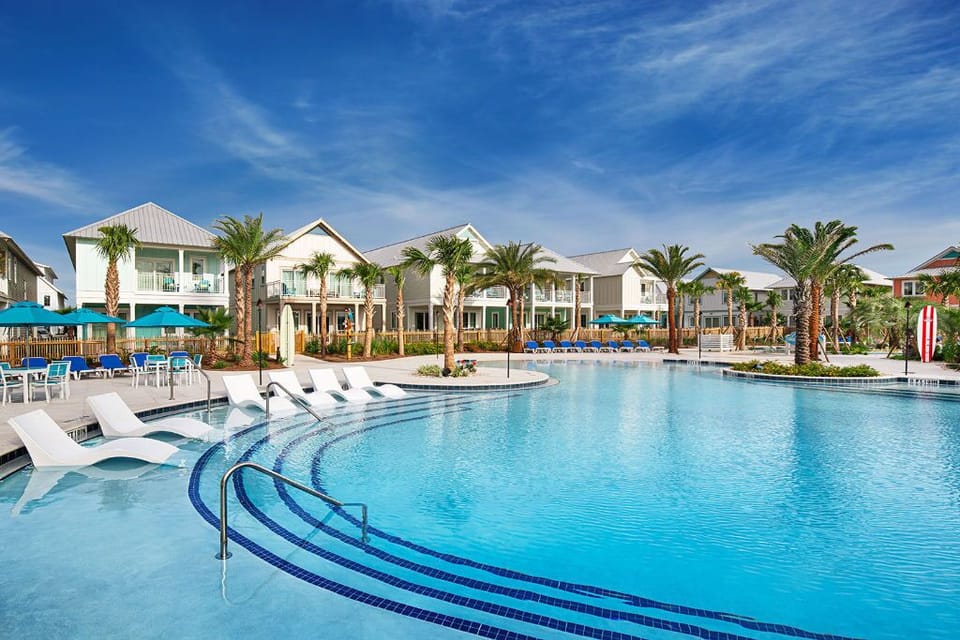 Take a dip in the inviting pool, surrounded by palm trees and vibrant lounge chairs.