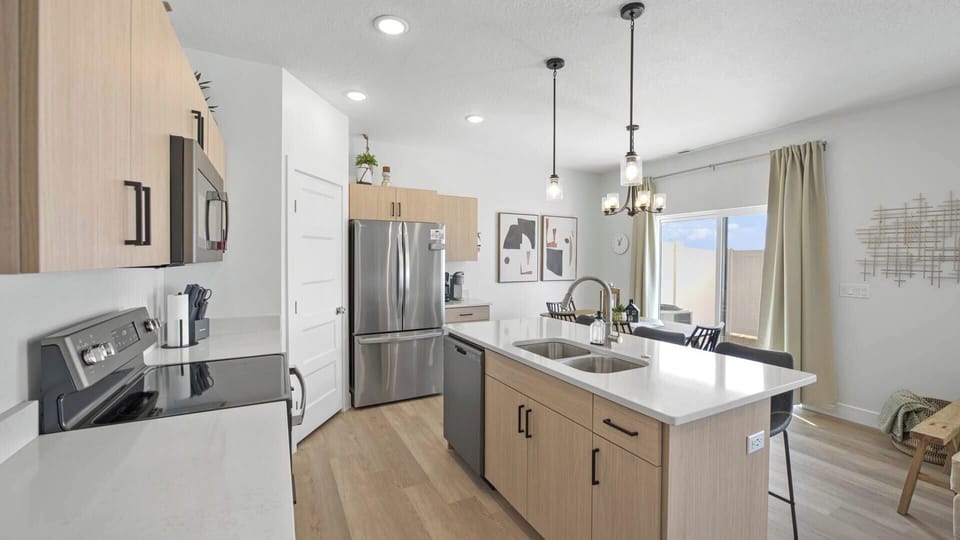 The kitchen features ample counter space and a 3-seat island, perfect for meal prep, socializing, and creating lasting memories.
