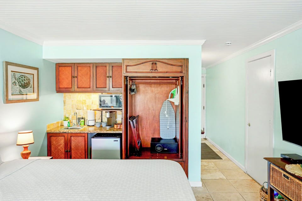 Armoire with hangers for clothing, luggage rack, ironing board & iron and safe. 