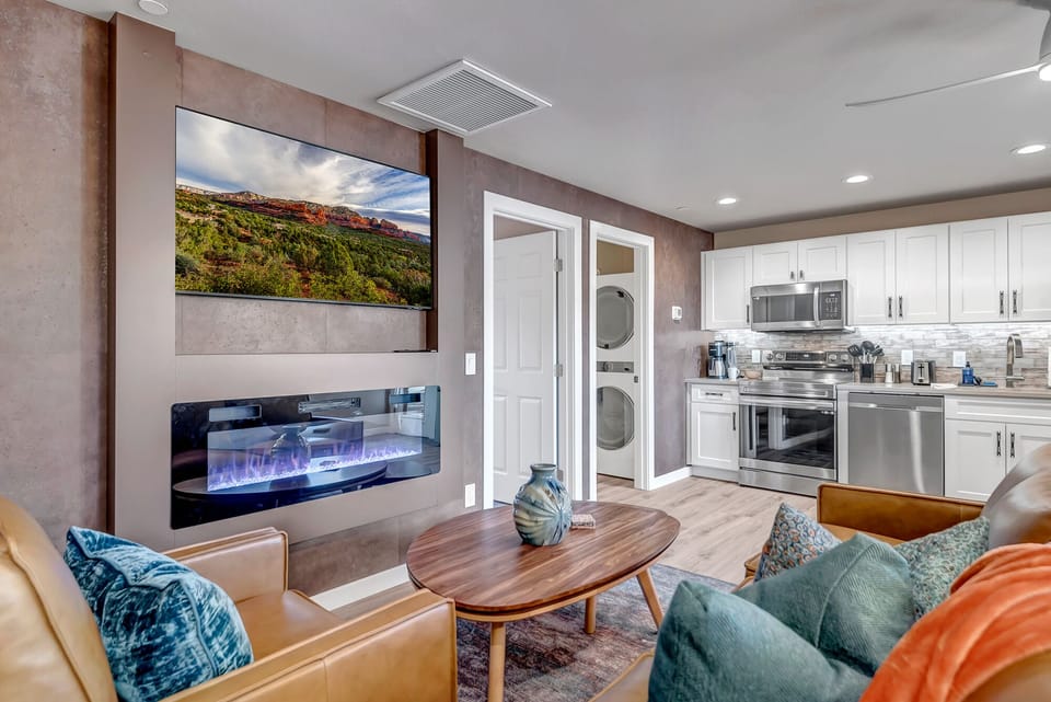 Living area with leather sofa, smart TV, and electric fireplace