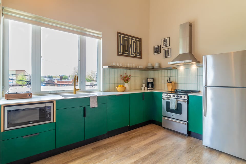 Sleek kitchen is fully equipped and features stainless steel appliances.