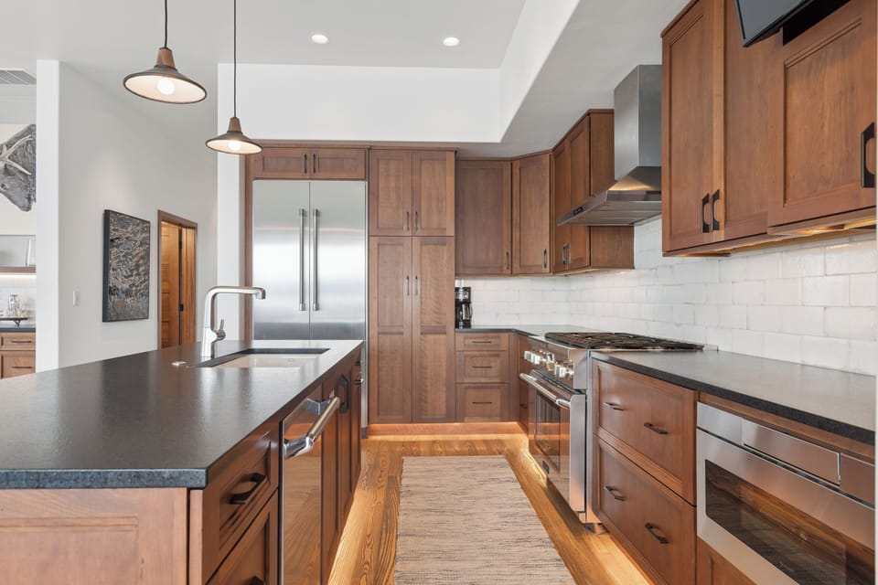 Step into your fully-equipped gourmet kitchen, where sleek appliances and rich wood cabinetry create the perfect space for preparing meals during your stay.