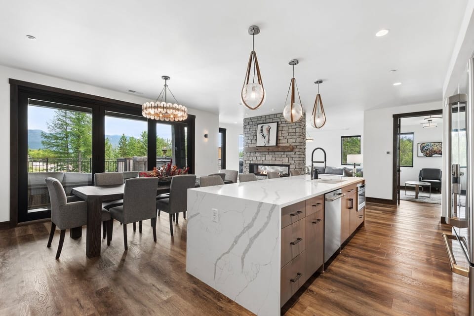 Gather around your stunning kitchen island with waterfall marble and enjoy mountain views through expansive windows. This bright, modern space blends natural wood warmth with sleek design—perfect for cooking together and making memories.