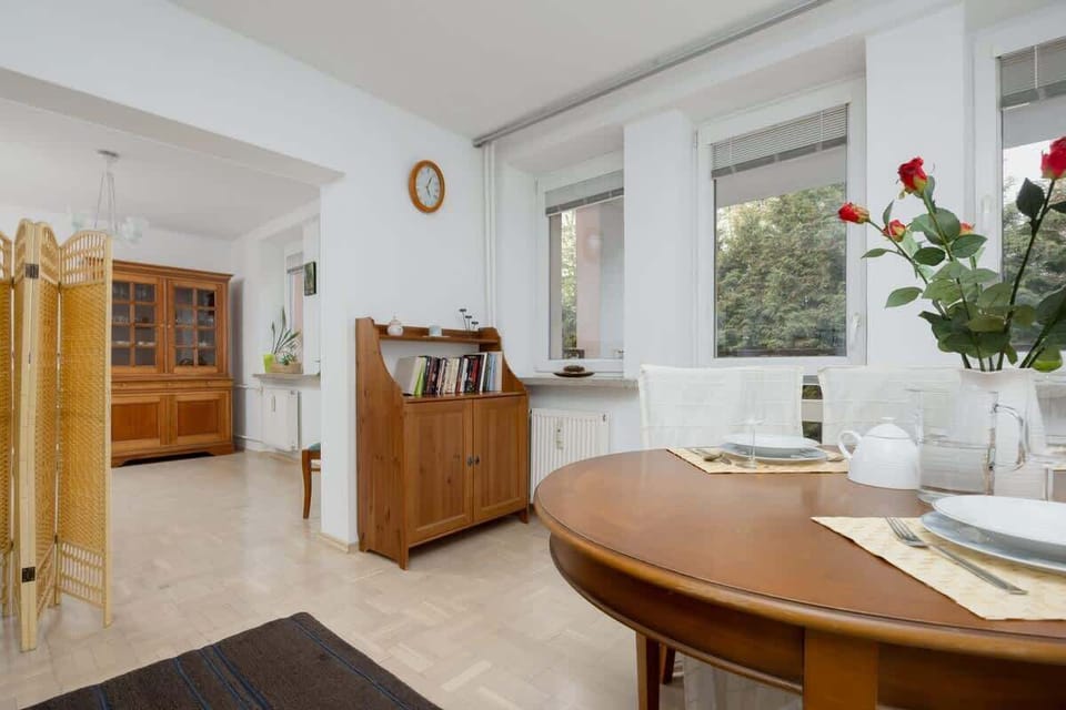 Living room with dining table, dark carpet, and wall decorations.