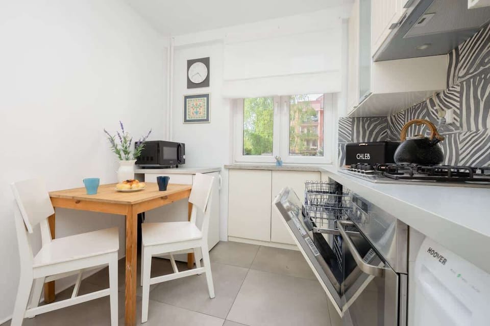 Kitchen with white cabinets, washing machine, and tiled backsplash.