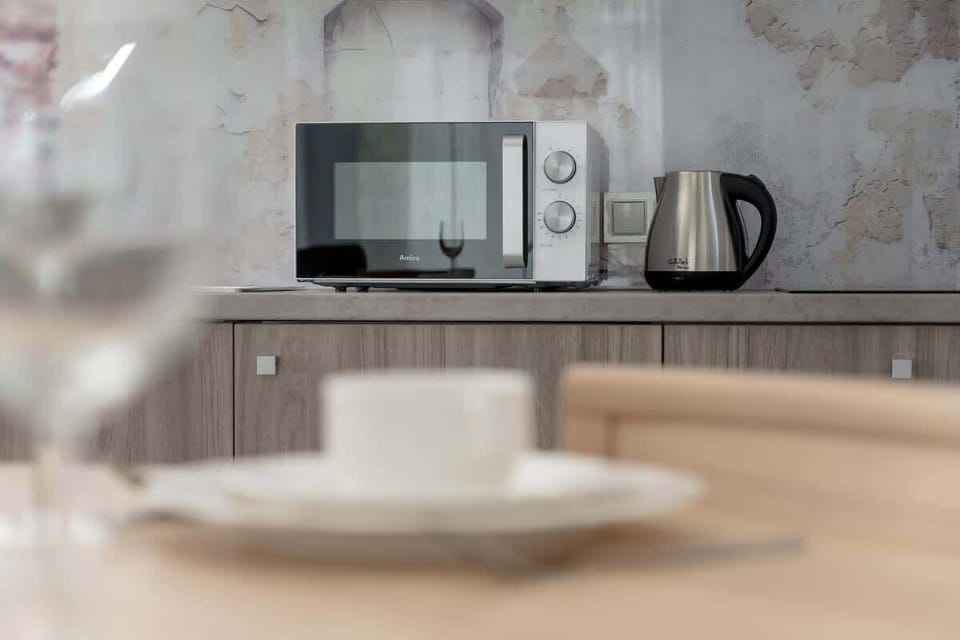 A close-up of a microwave and electric kettle on the kitchen counter. Perfect for preparing quick snacks and beverages.