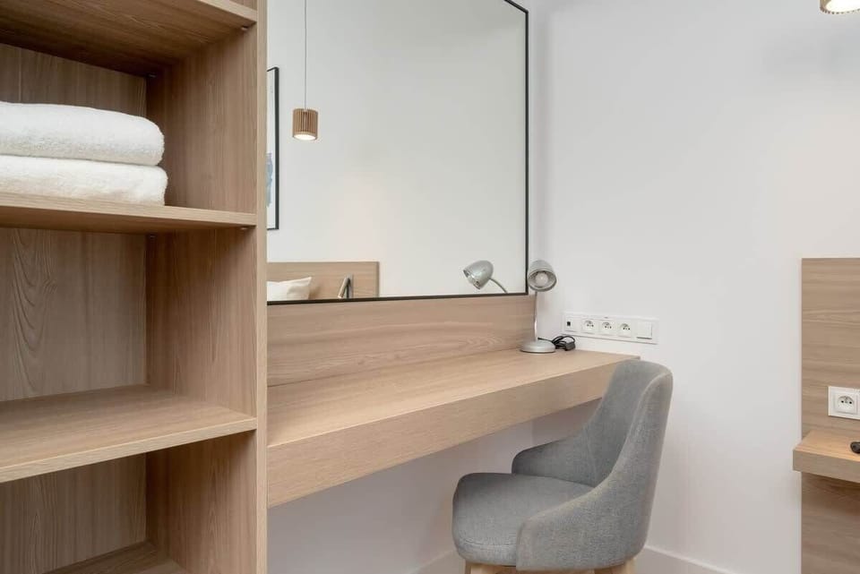 A close-up of the bedroom vanity area with shelves, mirror, and lighting. Great for preparing for the day or night out.
