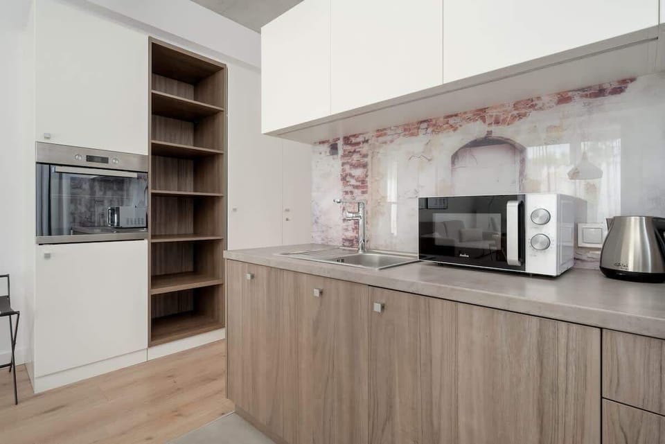 A well-equipped kitchen with wooden cabinetry, microwave, and coffee maker. Functional and aesthetically pleasing for meal preparation.
