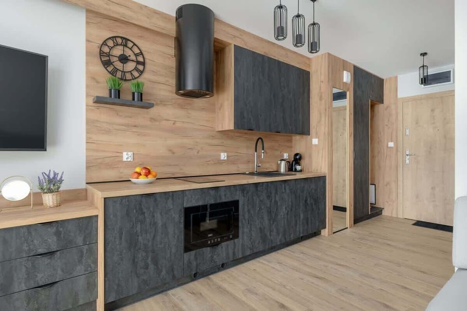 A compact and modern kitchenette with wooden countertops, a sink, and built-in cabinets, ideal for quick meals and coffee breaks.