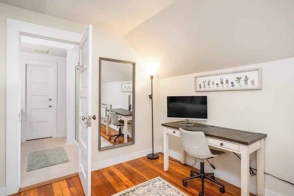 Workspace with desk, TV, and full mirror.