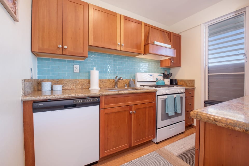 The updated kitchen is fully stocked with full size clean white appliances