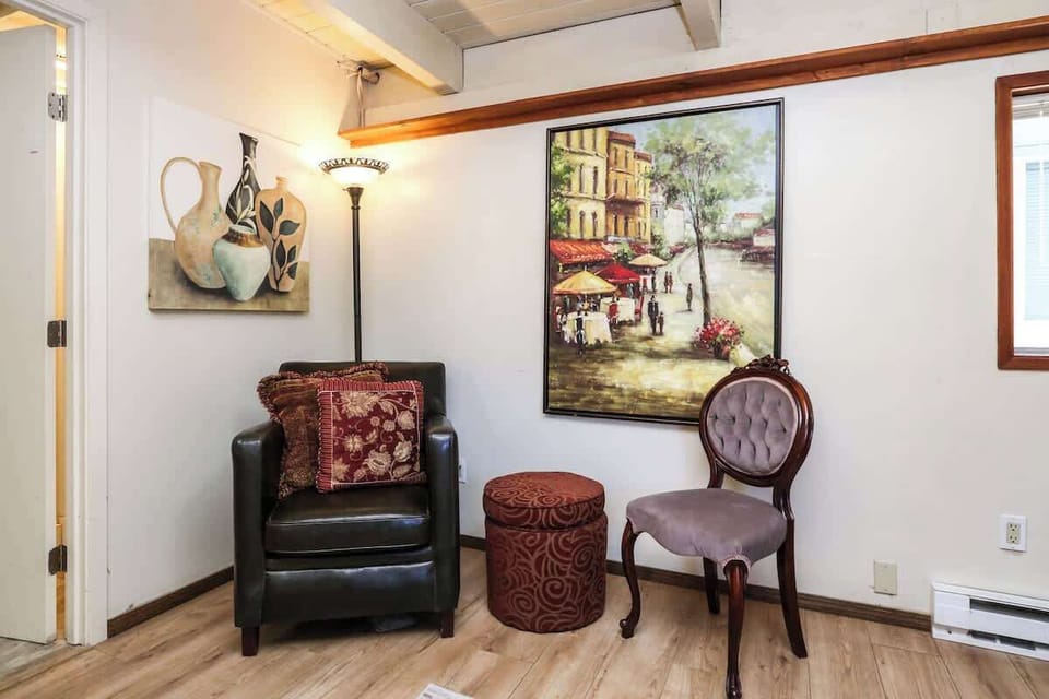 Bedroom #1 offers a spacious retreat with a cozy queen bed, warm wood accents, and large windows that fill the room with natural light. Thoughtfully furnished for comfort and relaxation.