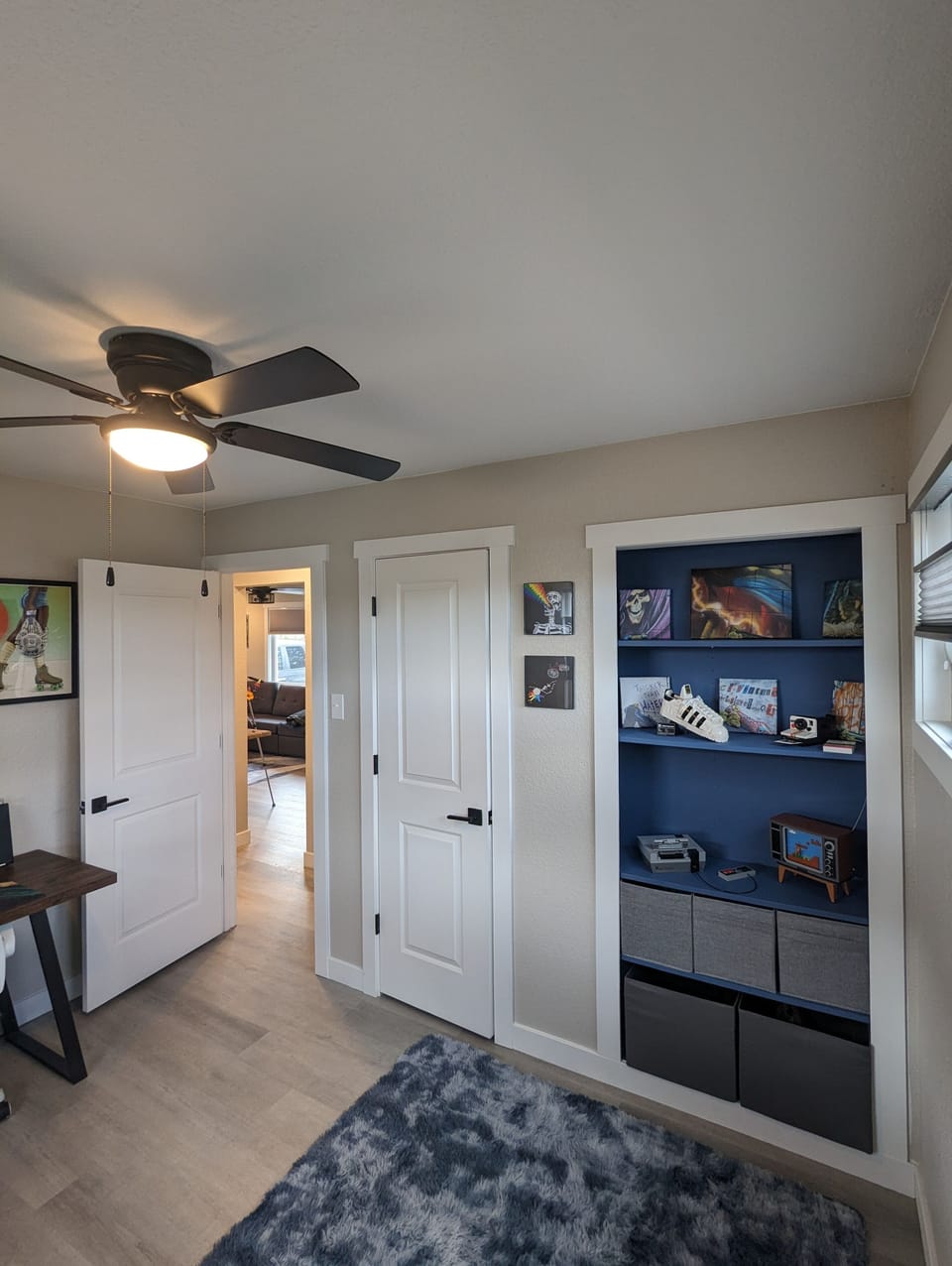 Full closet with display cabinets, original artwork, black-out blinds & storage.