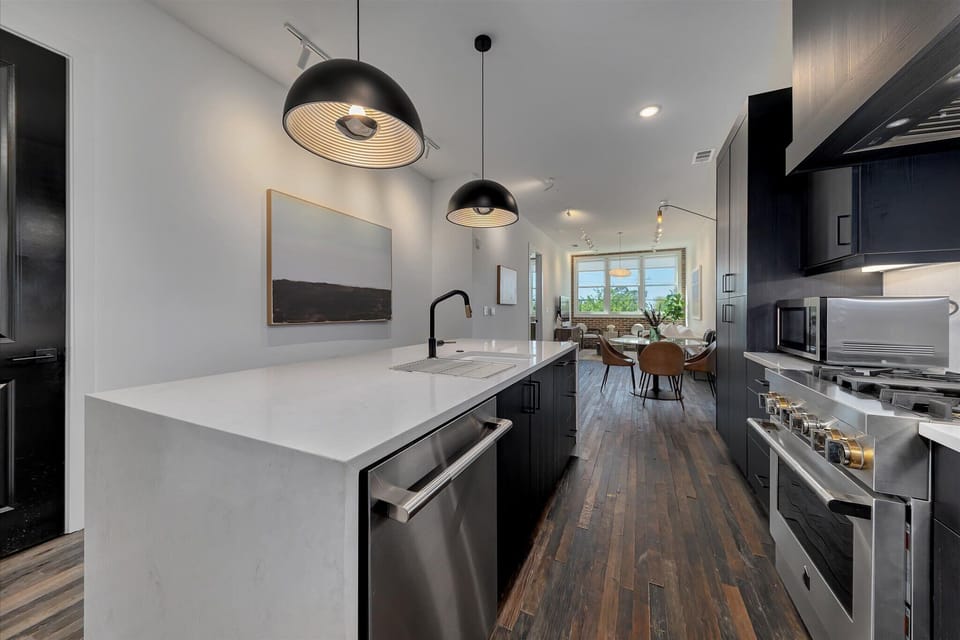 Spacious kitchen w/ waterfall island, pendant lighting & open layout