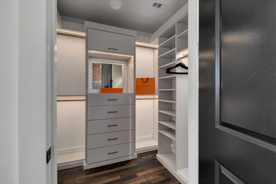 Organized closet space w/ shelving, hanging rods & central drawers