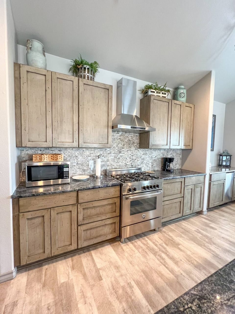 Modern kitchen in Bluffs Landing, Corpus Christi. Stainless steel appliances, gas stove, and plenty of storage. Perfect for cooking and entertaining. Stylish blend of rustic and modern design.