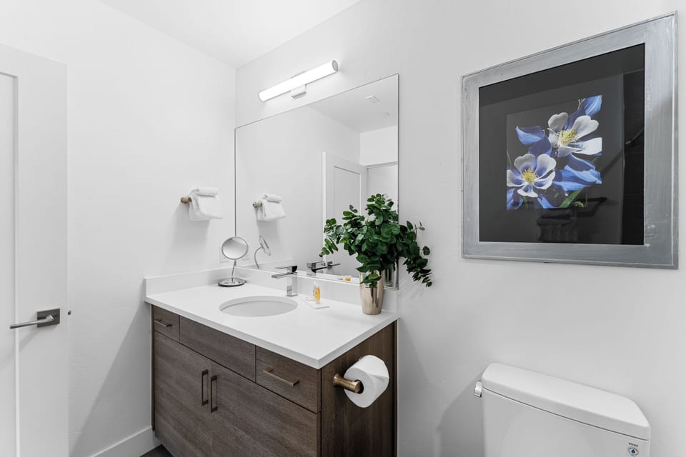 Step into your elegantly designed bathroom with modern vanity, fresh linens, and stylish artwork creating a serene space for your morning routine.