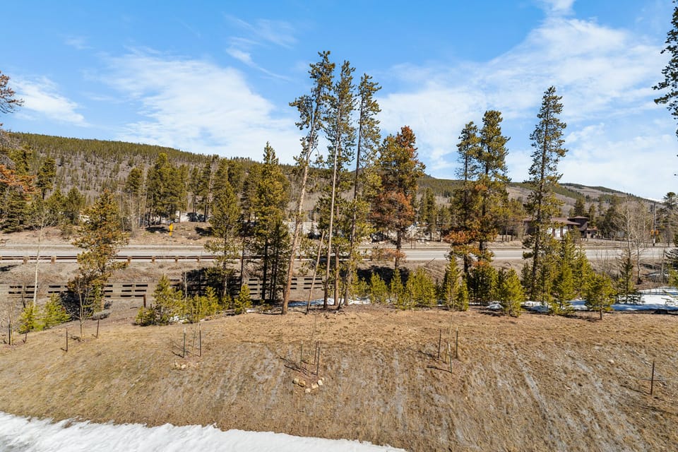 Mountain valley setting with forested hills and open meadows surrounding the property area.