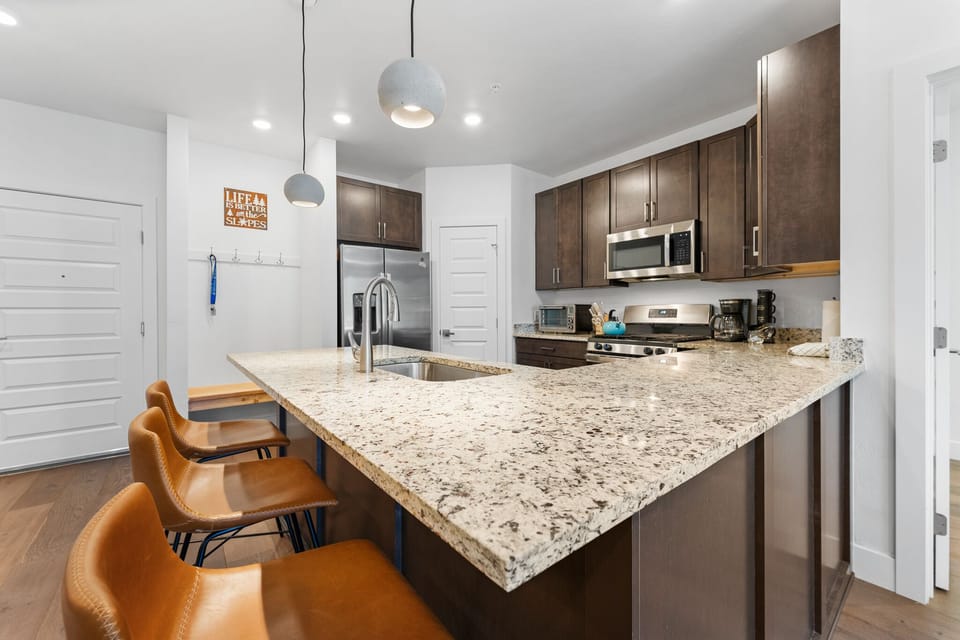 Cook memorable meals in your fully-equipped kitchen featuring granite countertops, modern appliances, and a breakfast bar perfect for morning coffee.