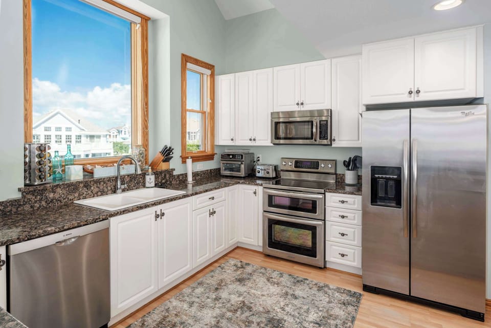 Top Level Fully Equipped Kitchen with a Refrigerator, Microwave, Dishwasher, Coffee Maker, Toaster Oven, Breakfast Bar, Natural Daylight, and Scenic Views.