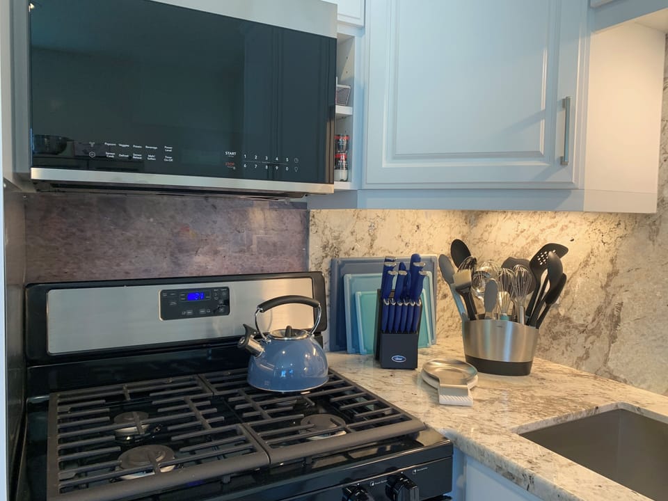 Kitchen - built-in microwave, gas stove, stainless steel sink & cooking utensils
