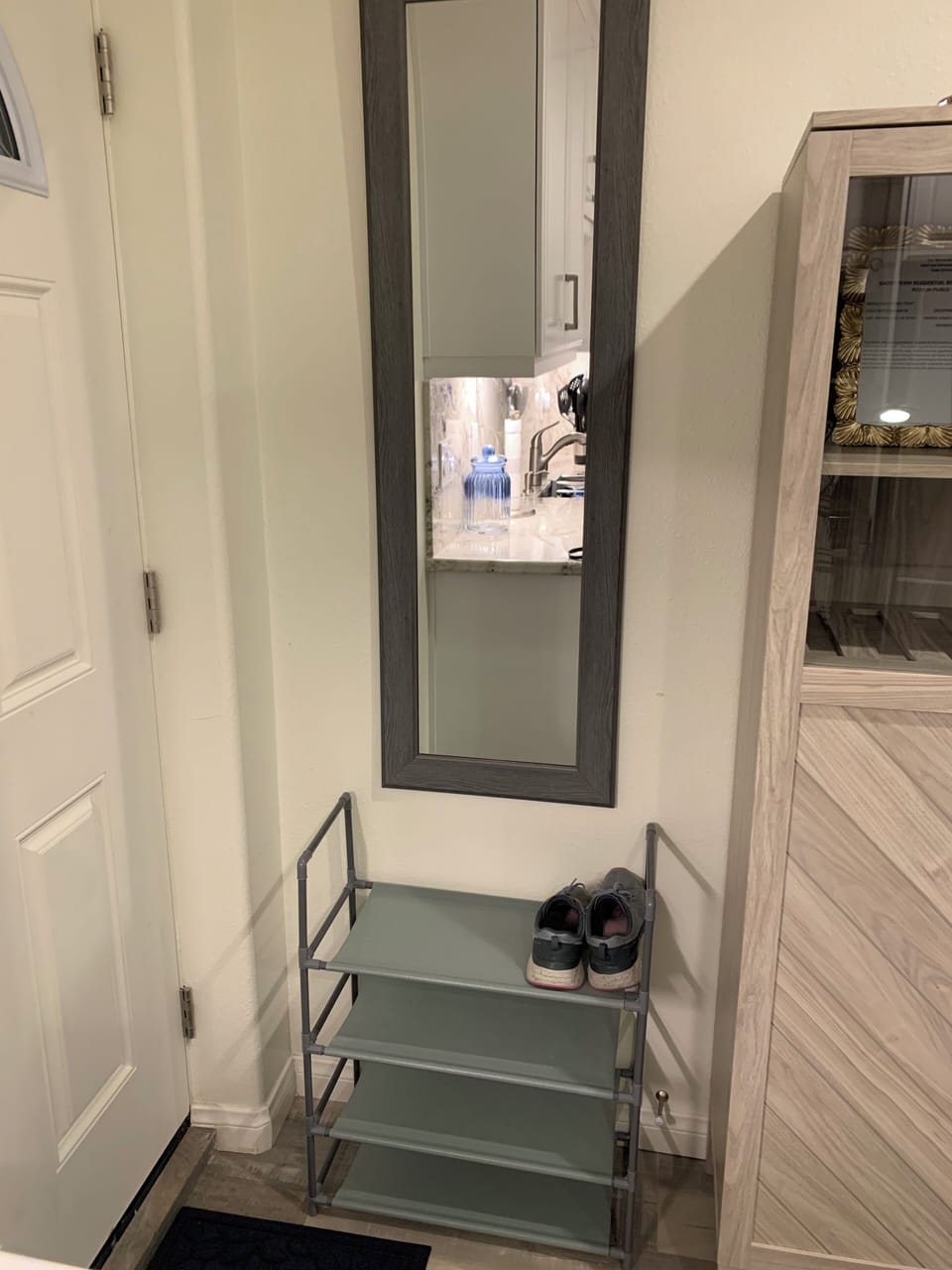 Wall-mounted full/length mirror &
shoe rack behind front entry door to unit