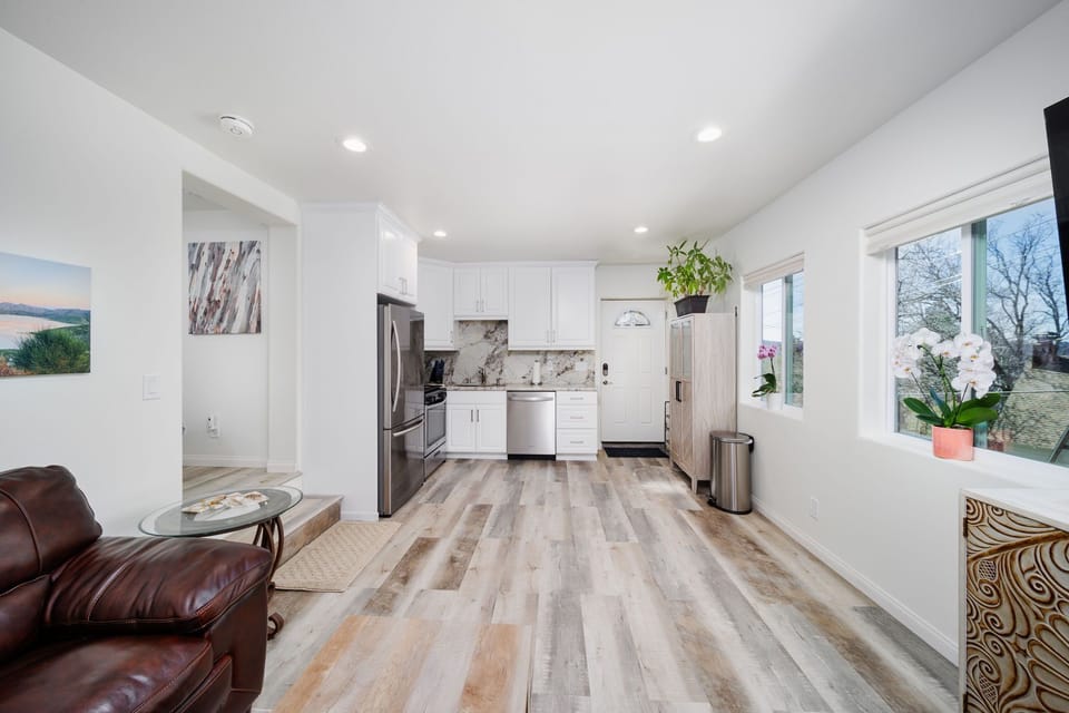 View of kitchen from living room w/natural light & beautiful views thru windows