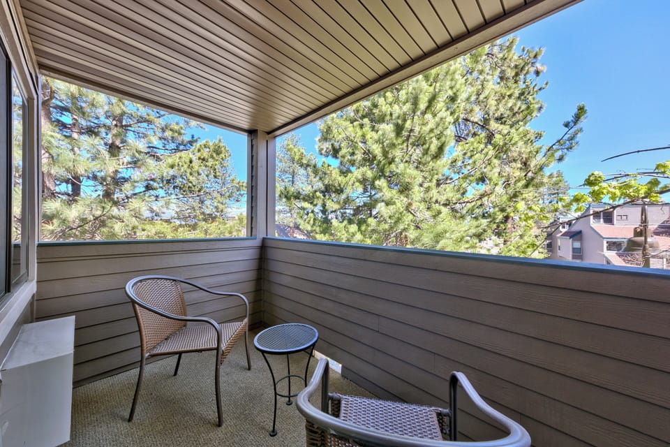 Sip your morning coffee on this peaceful balcony while enjoying treetop views and fresh mountain air through the screened comfort.