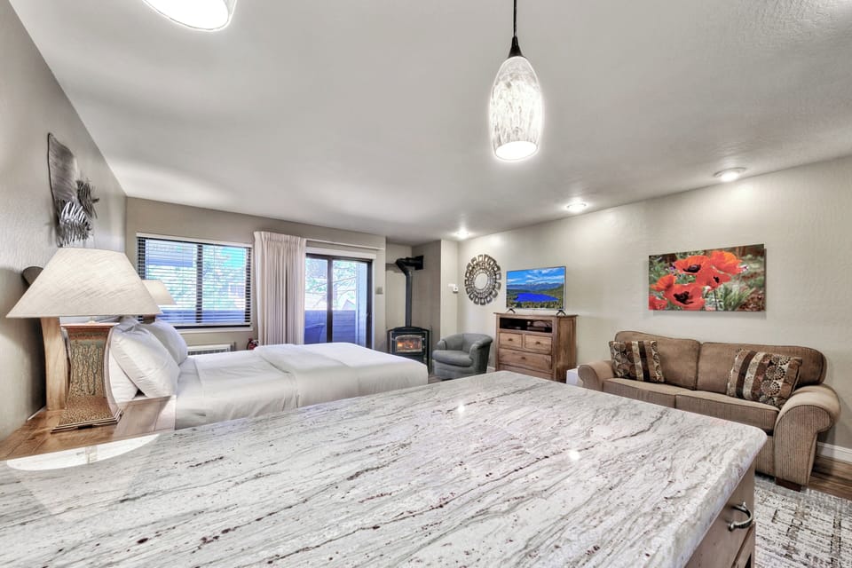 Unwind in your spacious studio featuring a comfortable beds, cozy fireplace, and relaxing seating area for the perfect mountain retreat.
