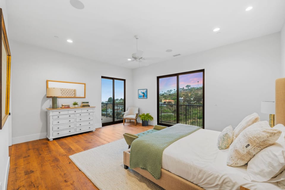 Spacious king bedroom with expansive windows filled with natural light and serene views.