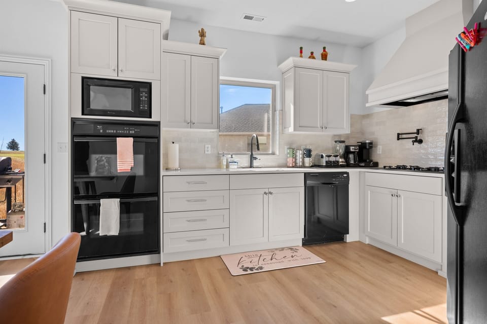 This well-equipped kitchen features a gas stove, keurig and drip coffeemakers, dishwasher, microwave, and double oven.