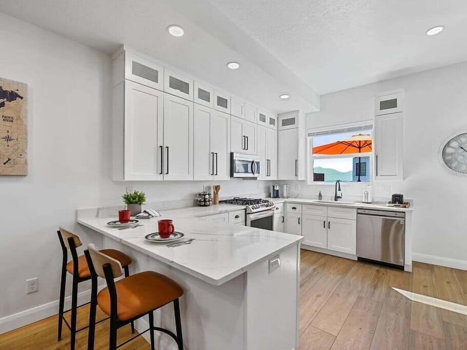 The gourmet kitchen features breakfast bar with seating for two and is equipped with stainless steel appliances, including a microwave, gas stove, and spacious refrigerator.