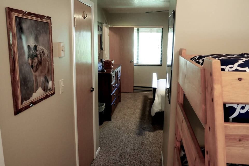 The bunk bed in the loft area is separated from the second bedroom by a closet wall.