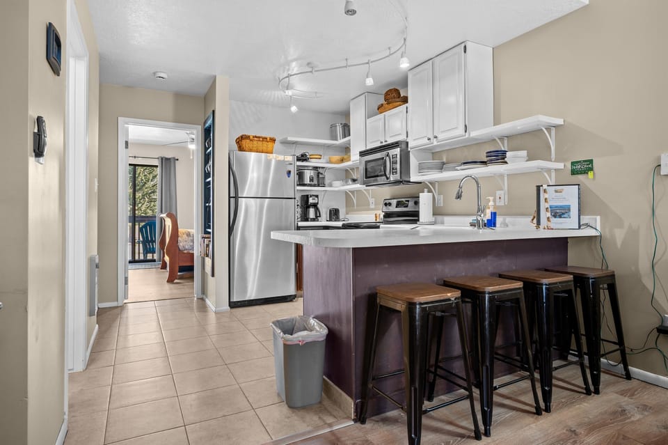 Breakfast bar with seating for four, opening to the kitchen and dining area for easy conversation.