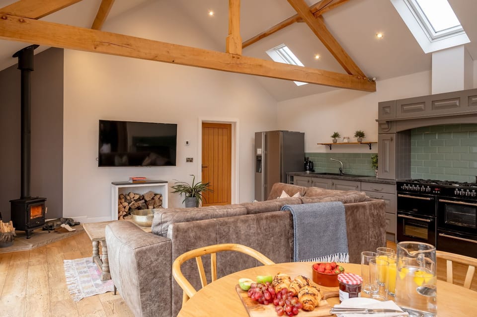 Modern bathroom with freestanding roll-top bath and walk-in shower in Millfield Barn.