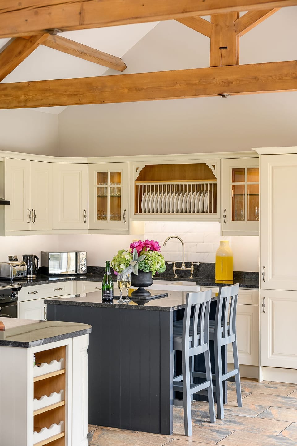 Open-plan living, dining and kitchen area at Kingfisher holiday cottage with exposed beams.