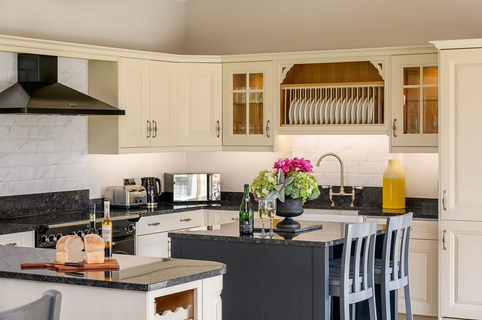 Open-plan living, dining and kitchen area at Kingfisher holiday cottage with exposed beams.
