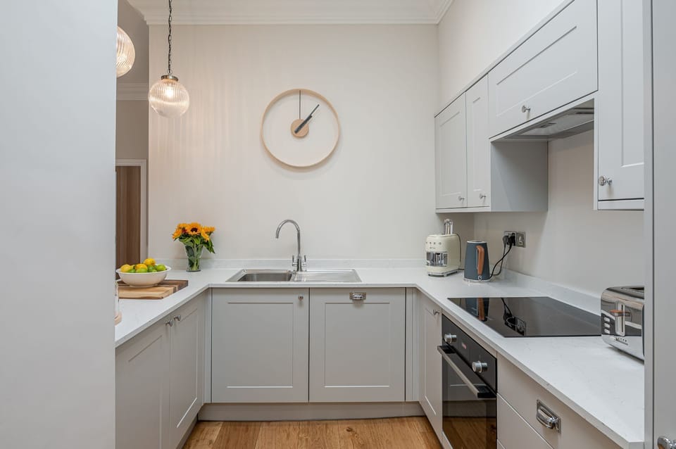 The Swaledale modern kitchen with grey cabinetry, integrated appliances and breakfast bar.