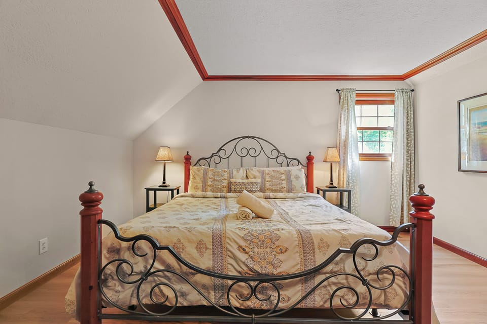 Second-floor bedroom: King bed featuring rustic charm, comfortable furnishings, and woodland views.