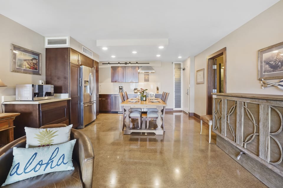 A stylish open-concept kitchen and dining area featuring a farmhouse-style dining table, stainless steel appliances, and beautiful wood finishes for a cozy, home-like feel.